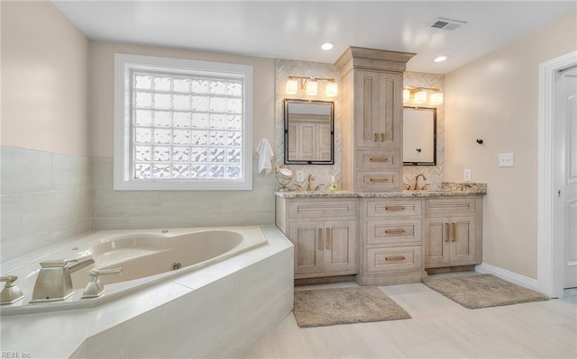 bathroom featuring double vanity, visible vents, decorative backsplash, a whirlpool tub, and a sink