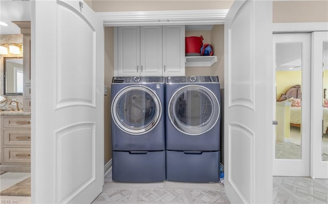 laundry room featuring cabinet space, independent washer and dryer, and a sink