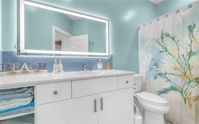 bathroom featuring tasteful backsplash, vanity, toilet, and curtained shower