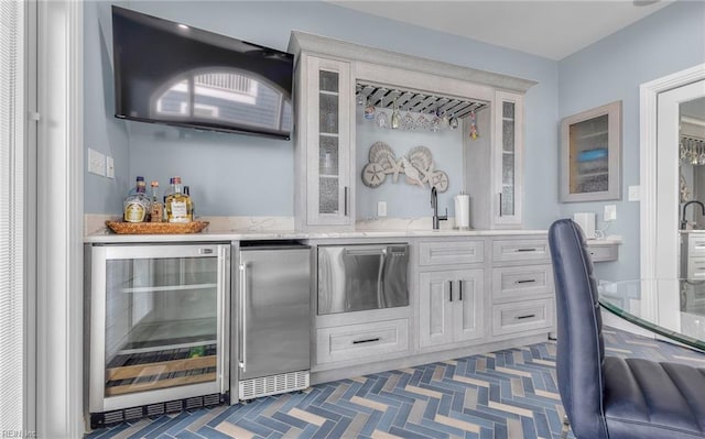 bar featuring beverage cooler, high end refrigerator, indoor wet bar, and refrigerator