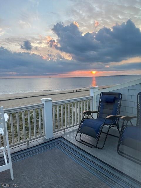 balcony at dusk with a water view and a beach view