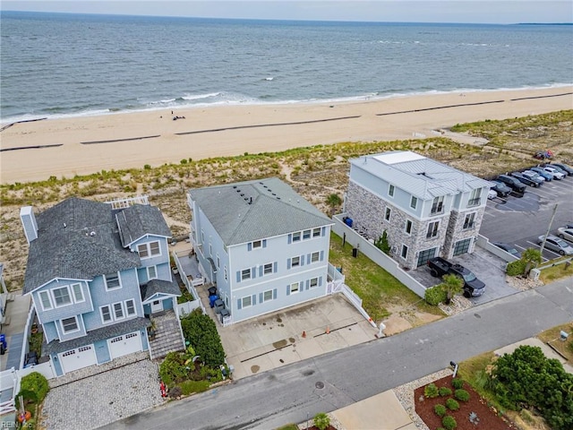 birds eye view of property with a water view and a beach view