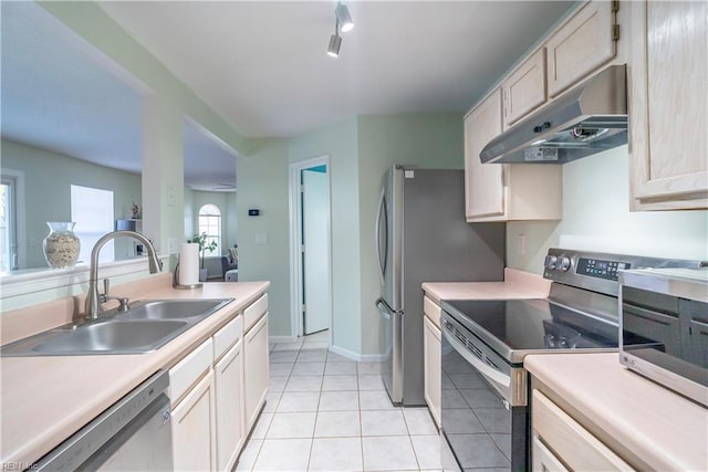 kitchen with a sink, under cabinet range hood, stainless steel appliances, and light countertops