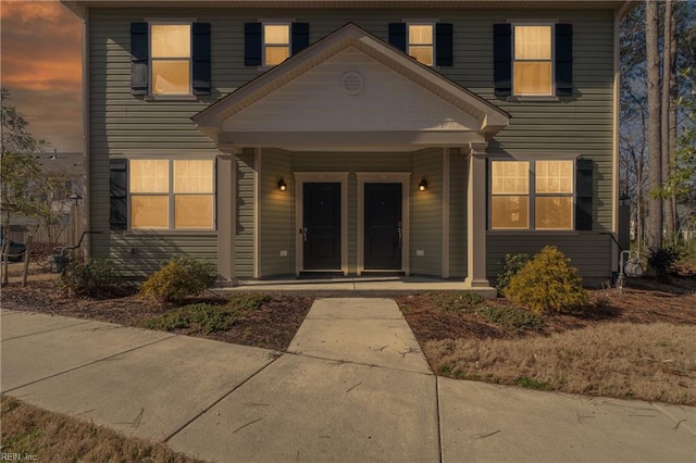 exterior entry at dusk with covered porch