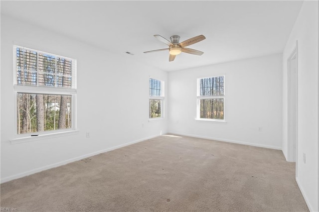 unfurnished room featuring ceiling fan, baseboards, visible vents, and light colored carpet