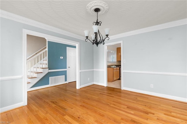 unfurnished dining area featuring stairway, wood finished floors, visible vents, and baseboards