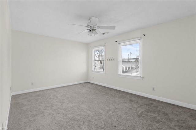 carpeted empty room with baseboards and a ceiling fan