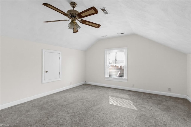 additional living space with ceiling fan, carpet floors, visible vents, baseboards, and vaulted ceiling