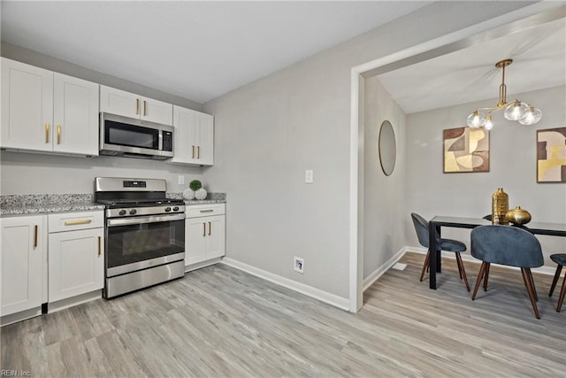 kitchen with white cabinets, light wood-style floors, and stainless steel appliances