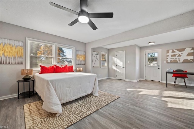 bedroom with ceiling fan, baseboards, and wood finished floors