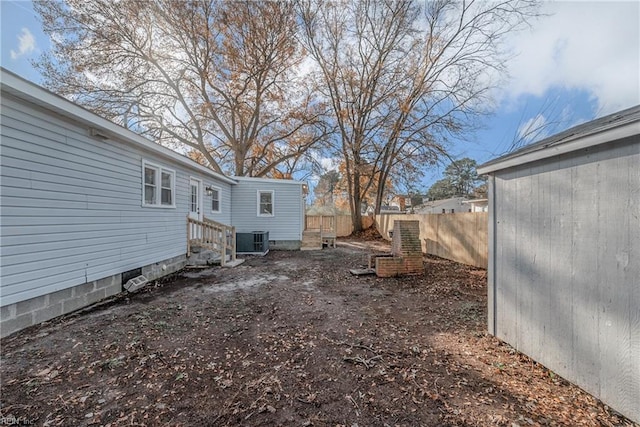 view of yard with fence and central air condition unit