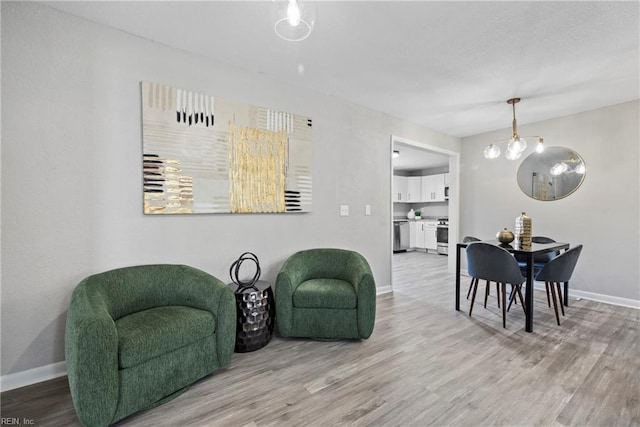 living area with baseboards and wood finished floors