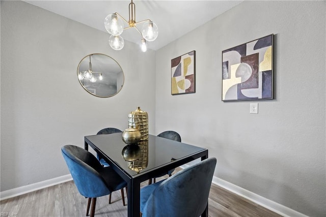 dining room featuring baseboards, a chandelier, and wood finished floors