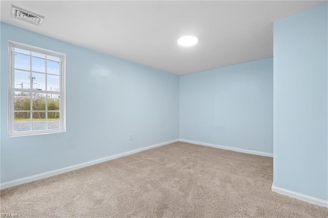 empty room featuring light carpet, baseboards, and visible vents