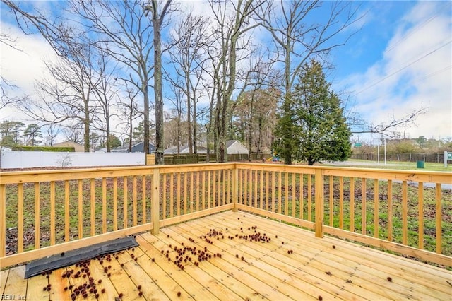 wooden terrace with a fenced backyard