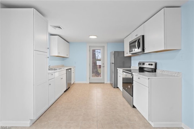 kitchen featuring visible vents, light countertops, appliances with stainless steel finishes, and white cabinetry