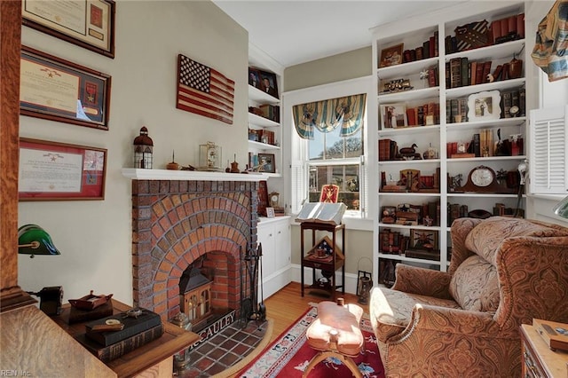 sitting room featuring a fireplace and wood finished floors