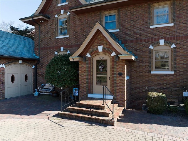 tudor house featuring a garage and brick siding