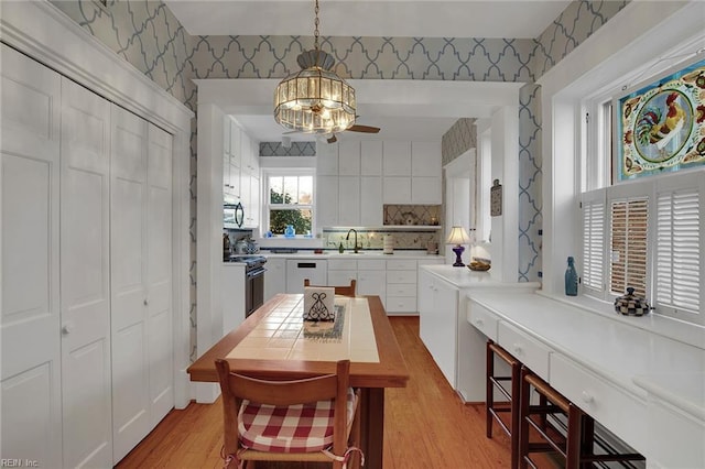 dining area with wallpapered walls and light wood-style flooring