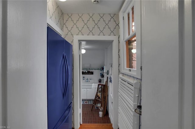 hallway with a sink and wallpapered walls