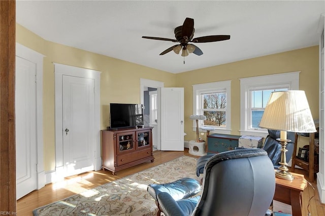 office with light wood-style floors and a ceiling fan