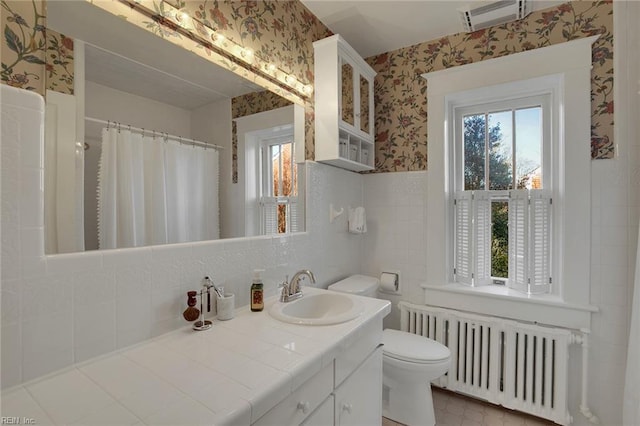 full bathroom featuring wallpapered walls, visible vents, toilet, radiator heating unit, and vanity