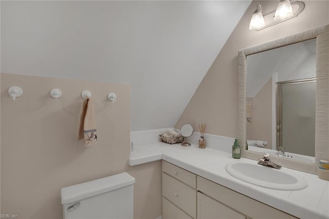 bathroom with vaulted ceiling, a shower with shower door, vanity, and toilet