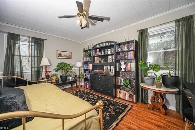 bedroom featuring wood finished floors and crown molding