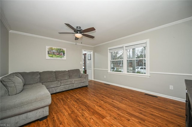 living room featuring crown molding, visible vents, a ceiling fan, wood finished floors, and baseboards