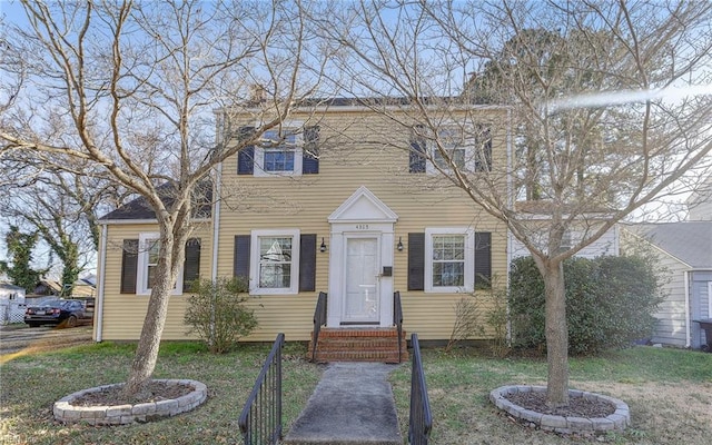 colonial inspired home featuring entry steps and a front lawn