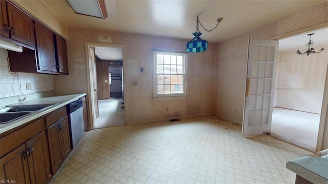 kitchen featuring wallpapered walls, light countertops, dishwasher, light floors, and pendant lighting