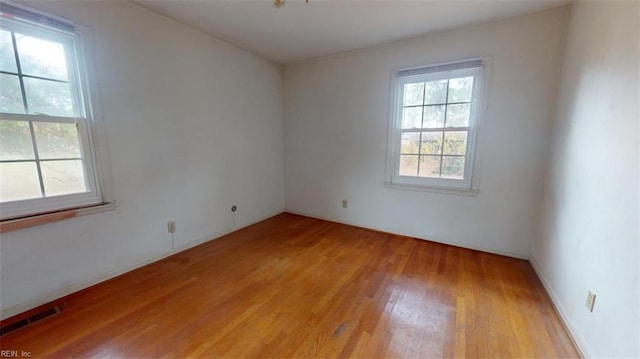 empty room featuring light wood finished floors and visible vents