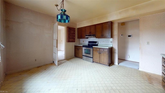 kitchen with wallpapered walls, under cabinet range hood, light countertops, and stainless steel electric stove