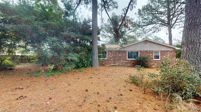 exterior space with brick siding and fence