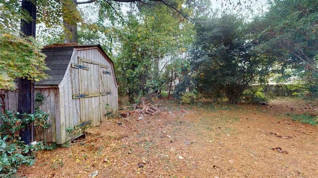 view of yard featuring an outbuilding, fence, and a storage unit