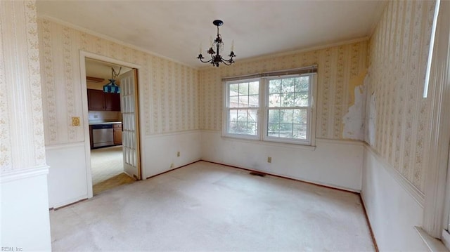 empty room with wallpapered walls, visible vents, a wainscoted wall, and light colored carpet