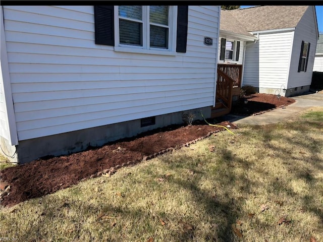 view of property exterior featuring crawl space, roof with shingles, and a yard