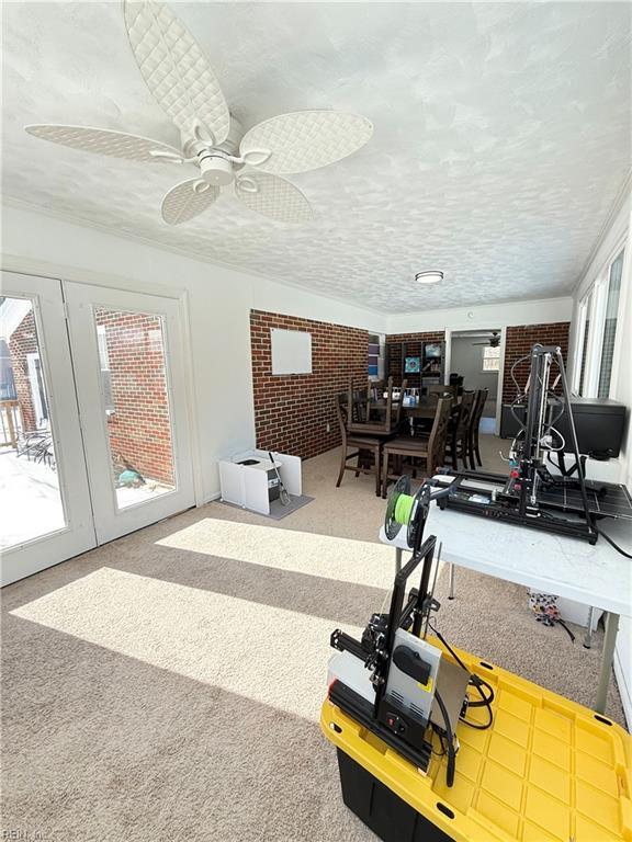 exercise room featuring french doors, carpet flooring, ceiling fan, and a textured ceiling