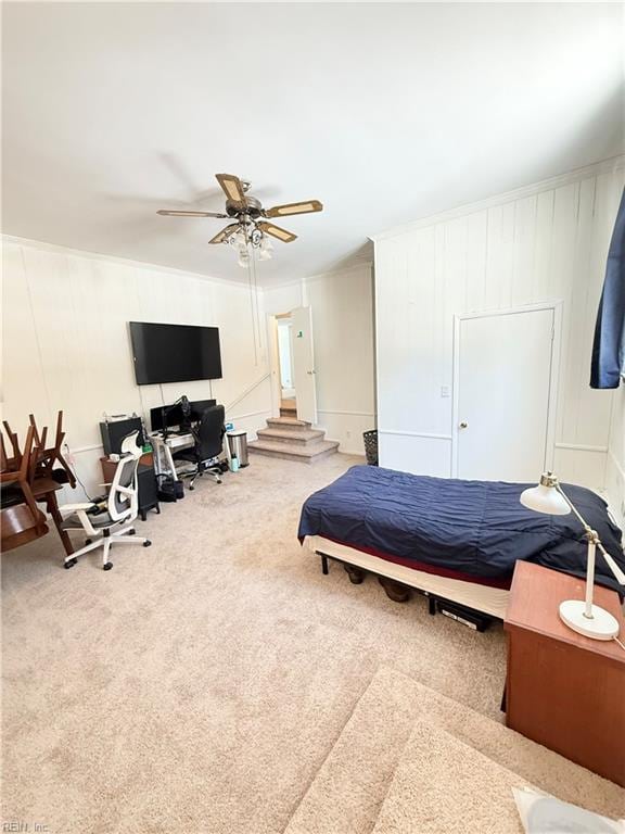 bedroom with ornamental molding, carpet, and a ceiling fan