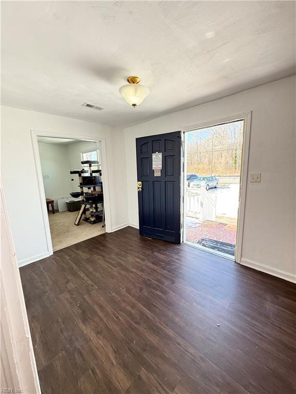 foyer featuring dark wood finished floors, visible vents, and baseboards