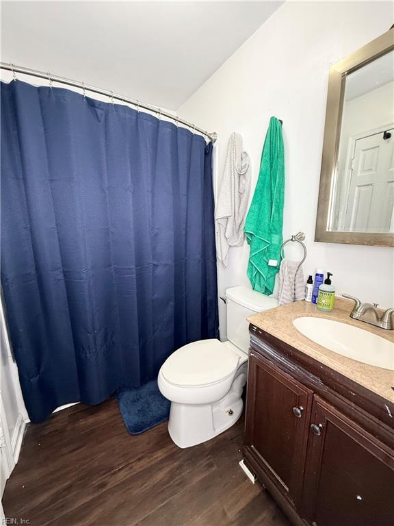 full bath with vanity, wood finished floors, and toilet