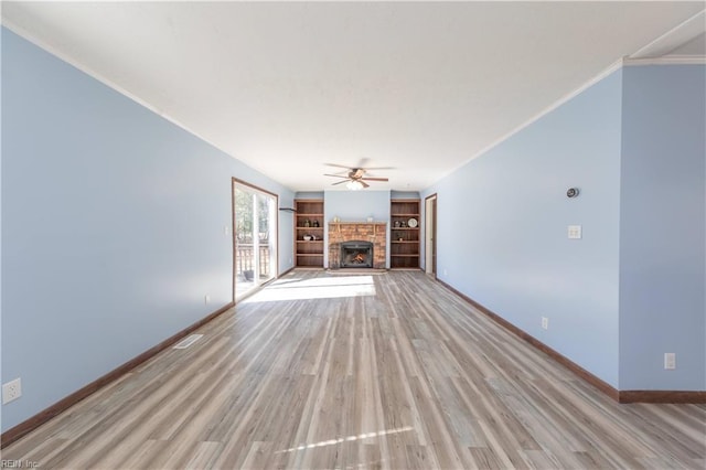 unfurnished living room featuring a warm lit fireplace, baseboards, a ceiling fan, crown molding, and light wood-type flooring