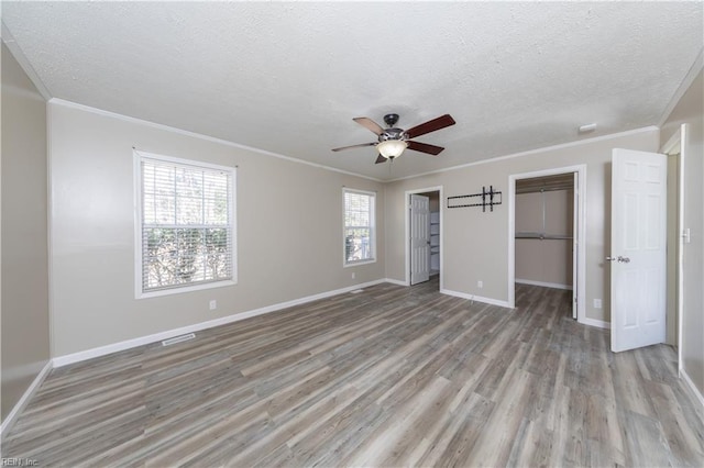 unfurnished bedroom featuring light wood-style flooring, baseboards, and a textured ceiling