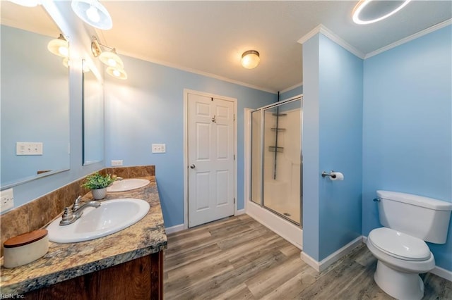 full bathroom featuring crown molding, a stall shower, a sink, and toilet