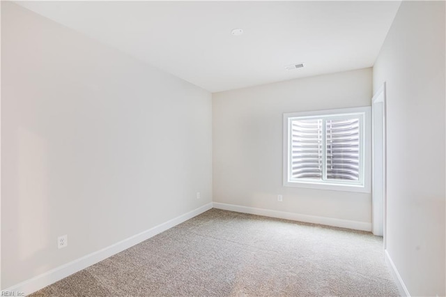 carpeted empty room featuring visible vents and baseboards