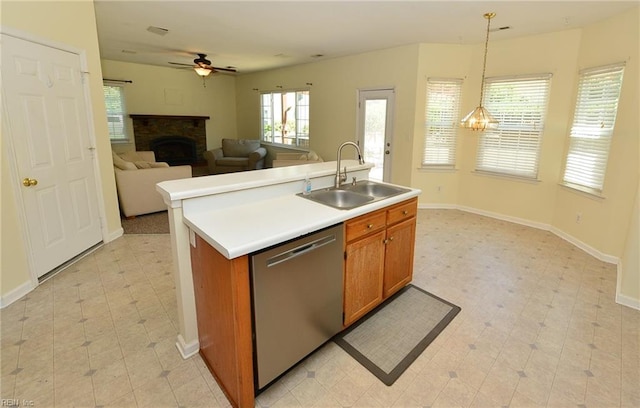 kitchen featuring a sink, open floor plan, light countertops, stainless steel dishwasher, and a center island with sink