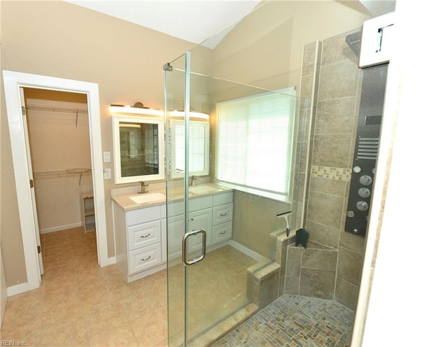 full bathroom featuring a stall shower, tile patterned floors, a sink, and double vanity