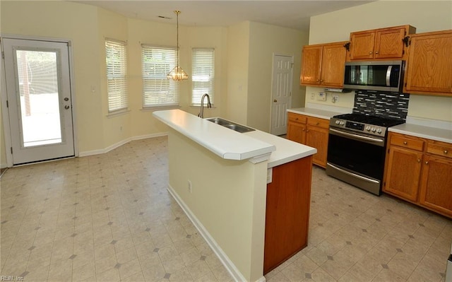 kitchen featuring light countertops, appliances with stainless steel finishes, light floors, and a sink