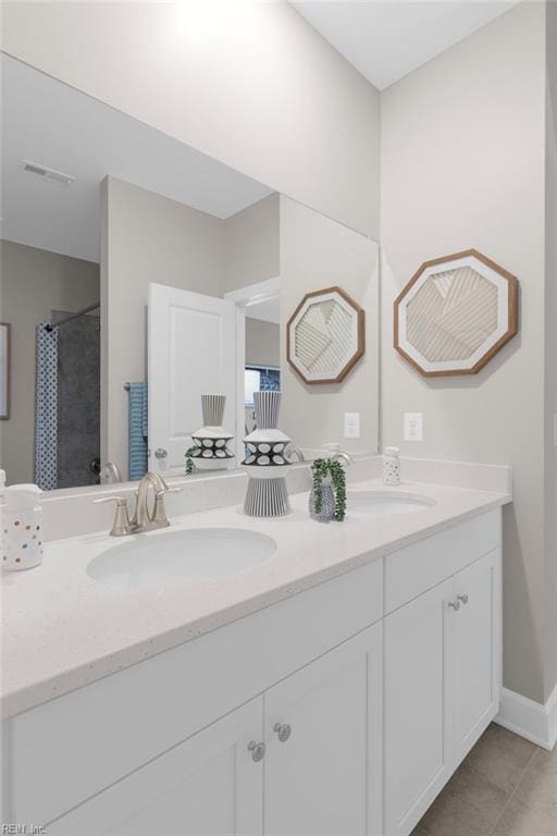 bathroom with double vanity, baseboards, visible vents, a shower with shower curtain, and a sink