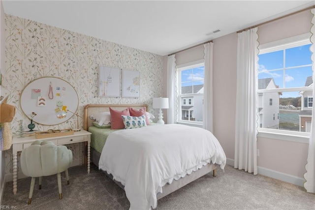 bedroom featuring carpet floors, wallpapered walls, visible vents, and baseboards